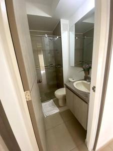 a bathroom with a toilet and a sink and a mirror at Ven a recargar energías. in Girardot