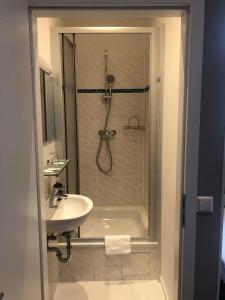 a bathroom with a shower and a sink and a tub at Hotel Gasteiner Hof in Berlin