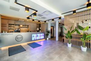 an office lobby with a reception counter and plants at B&B Hotel Wien-Stadthalle in Vienna