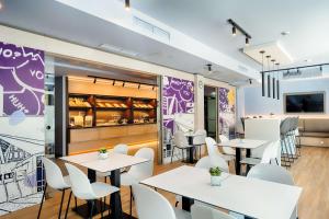 a restaurant with white tables and white chairs at B&B Hotel Wien-Stadthalle in Vienna