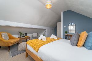 a bedroom with a large bed and a chair at Number One - Stones Court in St Ives