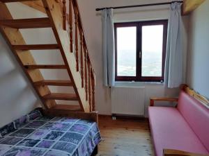 a bedroom with a staircase and a bed and a window at Panorama Family House in Palekastron