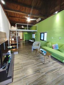 ein Wohnzimmer mit einem grünen Sofa und einem Etagenbett in der Unterkunft Humble Room in Hualien
