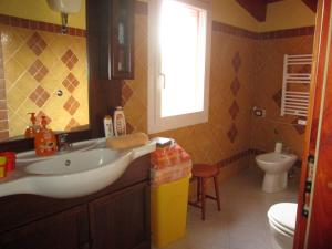 łazienka z umywalką, toaletą i oknem w obiekcie B&B Le Terrazze Isola Di S. Antioco w mieście SantʼAntìoco