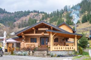 a log cabin in the mountains with smoke coming at Pensiunea Mireasma Bucovinei in Crucea
