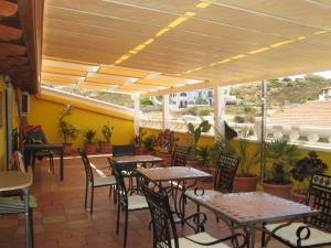 サンタンティーオコにあるB&B Le Terrazze Isola Di S. Antiocoのテーブルと椅子、パティオ付きのレストラン
