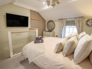 - une chambre avec un lit blanc et une télévision à écran plat dans l'établissement 14 Crown Lane, à Conwy