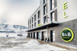 un bâtiment avec un panneau d'hôtel bbc dans la neige dans l'établissement B&B Hotel Willingen, à Willingen