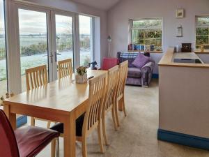 a kitchen and living room with a table and chairs at Bankswood Cottage in Ruthwell