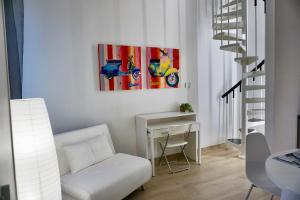 uma sala de estar com um sofá branco e uma mesa em LOFT 10 em Varese