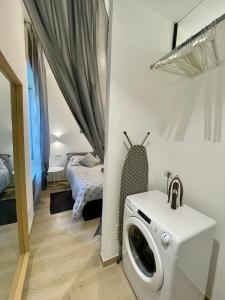 a laundry room with a washing machine and a bed at LOFT 10 in Varese