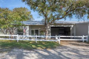 a white fence in front of a white house at Quaint Countryside Casita 45 Mi to Ft Worth in Buckner