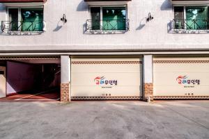 Gyorae Drive-in Motel في جيجو: زوج من أبواب الجراج أمام مبنى