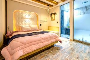 1 dormitorio con cama rosa y ventana grande en Gyorae Drive-in Motel en Jeju
