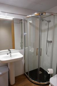 W łazience znajduje się szklana kabina prysznicowa i umywalka. w obiekcie ANCLA spaces EGVT-436-CS w mieście Vinarós