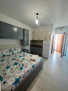 a bedroom with a bed with blue flowers on it at Kamberi Hotel & Apartments 2 in Velipojë