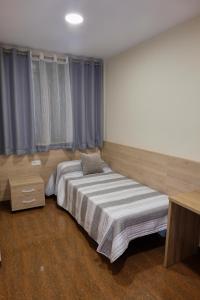 1 dormitorio con 1 cama grande y cortinas azules en ANCLA spaces EGVT-436-CS en Vinarós