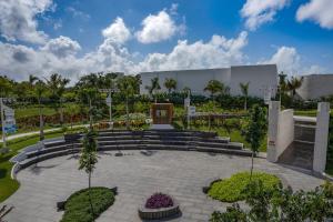 Nickelodeon Hotels & Resorts Riviera Maya - Gourmet All Inclusive by Karisma في بويرتو موريلوس: حديقة بها درج ومبنى به أشجار نخيل