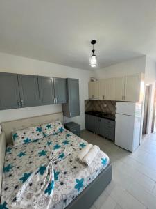 a bedroom with a bed with blue flowers on it at Kamberi Hotel & Apartments 2 in Velipojë