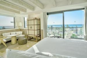 a bedroom with a large bed and a view of the ocean at Naay Boutique Hotel Holbox in Holbox Island