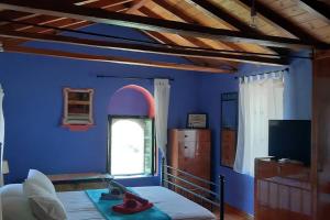 a blue room with a bed and a window at MARIA'S Rustic stonehouse in traditional village in Koúmani