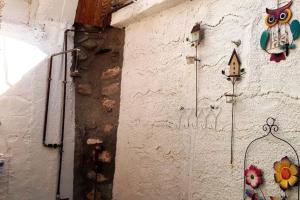 a wall with a painting of an owl and a butterfly at MARIA'S Rustic stonehouse in traditional village in Koúmani