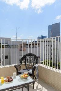 een tafel en stoelen op een balkon met eten erop bij Pleasent Day by HolyGuest in Tel Aviv