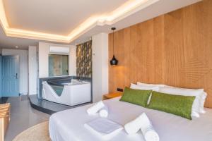 HOM54 Luxury Suites في مدينة هيراكيلون: غرفة نوم بسرير كبير وحوض استحمام