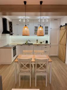 una cocina con mesa de madera y sillas. en APARTAMENTY GUZIK 22 en Krosno