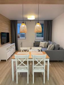 ein Wohnzimmer mit einem Tisch, Stühlen und einem Sofa in der Unterkunft APARTAMENTY GUZIK 22 in Krosno