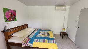 a bedroom with a bed with a colorful blanket on it at Sutopia Holiday Resort in Paramaribo
