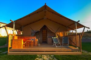 una grande tenda con tavolo e sedie su una terrazza di La Viola e il Sole - alloggi e glamping - a Fermo