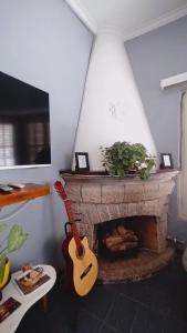 a guitar in a living room with a fireplace at Mora Hostel in Mendoza