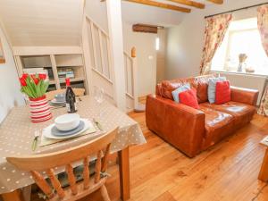 sala de estar con mesa y sofá en The Stable, Sedbury Park Farm, en Gilling