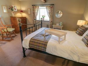 a bedroom with a bed with a table on it at The Stable, Sedbury Park Farm in Gilling
