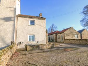 GillingにあるThe Stable, Sedbury Park Farmの石壁と二棟の古い石造りの家