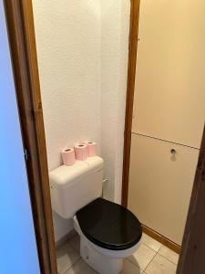 サン・ジャン・ドルプにあるJoli studio 4 Pers 30m des pistes balcon plein Sud au Pieds des Pistes B27- DRAPS NON COMPRISの黒い便座が付いた白いトイレのある小さなバスルーム