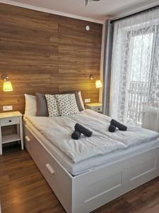 - une chambre avec un grand lit et un mur en bois dans l'établissement Rodzinna Ostoja, à Zakopane