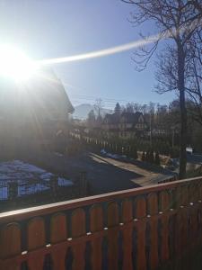 een hek voor een huis met zon bij Rodzinna Ostoja in Zakopane