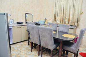 a dining room with a table and chairs and a sink at Jama Residence in Abuja