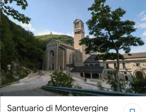 un grande edificio con una torre dell'orologio e un albero di Bella 'Mbriana ad Avellino