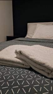 two beds with white towels on top of them at Wellness apartment BLACK-WHITE in Široki Brijeg