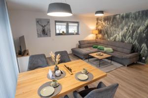 ein Wohnzimmer mit einem Tisch und einem Sofa in der Unterkunft Lindenberg Apartments in Wernigerode