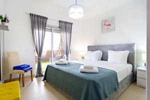 a bedroom with a large bed with towels on it at Fleming Apartment in Tavira +6 photos