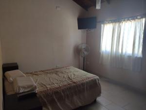 1 dormitorio con 1 cama, ventilador y ventana en Relax San Bernardo en San Bernardo