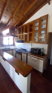 cocina con armarios de madera y encimera en Casa del Mar en Villa Gesell