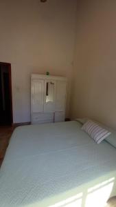 1 dormitorio con 1 cama grande y armario blanco en Casa del Mar en Villa Gesell