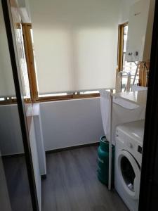 a bathroom with a washing machine and a sink at Beach House in Póvoa de Varzim