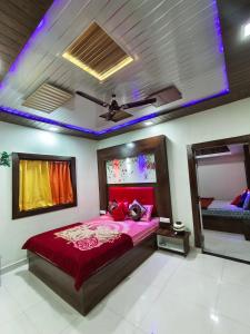 een slaapkamer met een rood bed en een plafond bij Krishna Niwas in Mahabaleshwar