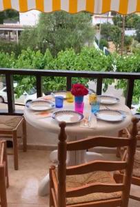 a table with plates and flowers on a balcony at Playa Las Fuentes Bello LUXURY Apartament Pp2 PET in Alcossebre